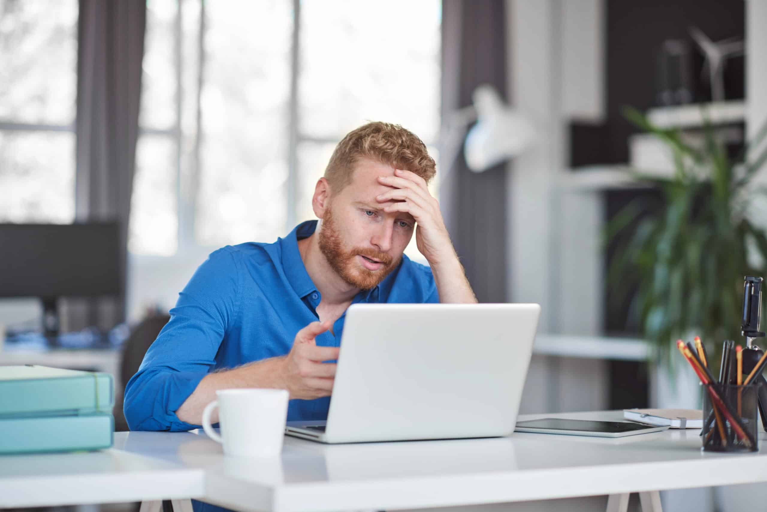 A man is frustrated with his underperforming computer, illustrating the benefits of leveraging hardware as a service.